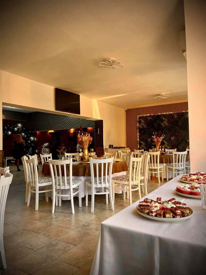 Sala Private Society Events aranjată pentru eveniment, cu mese rotunde și peretele verde